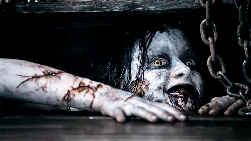 Grotesque possessed demon crawls out of a chained dark wooden compartment, reaching toward the vi...
