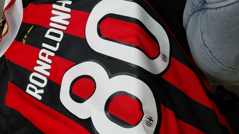 Red and black striped soccer jersey with the number 8 and "RONALDINHO" text along the stripes